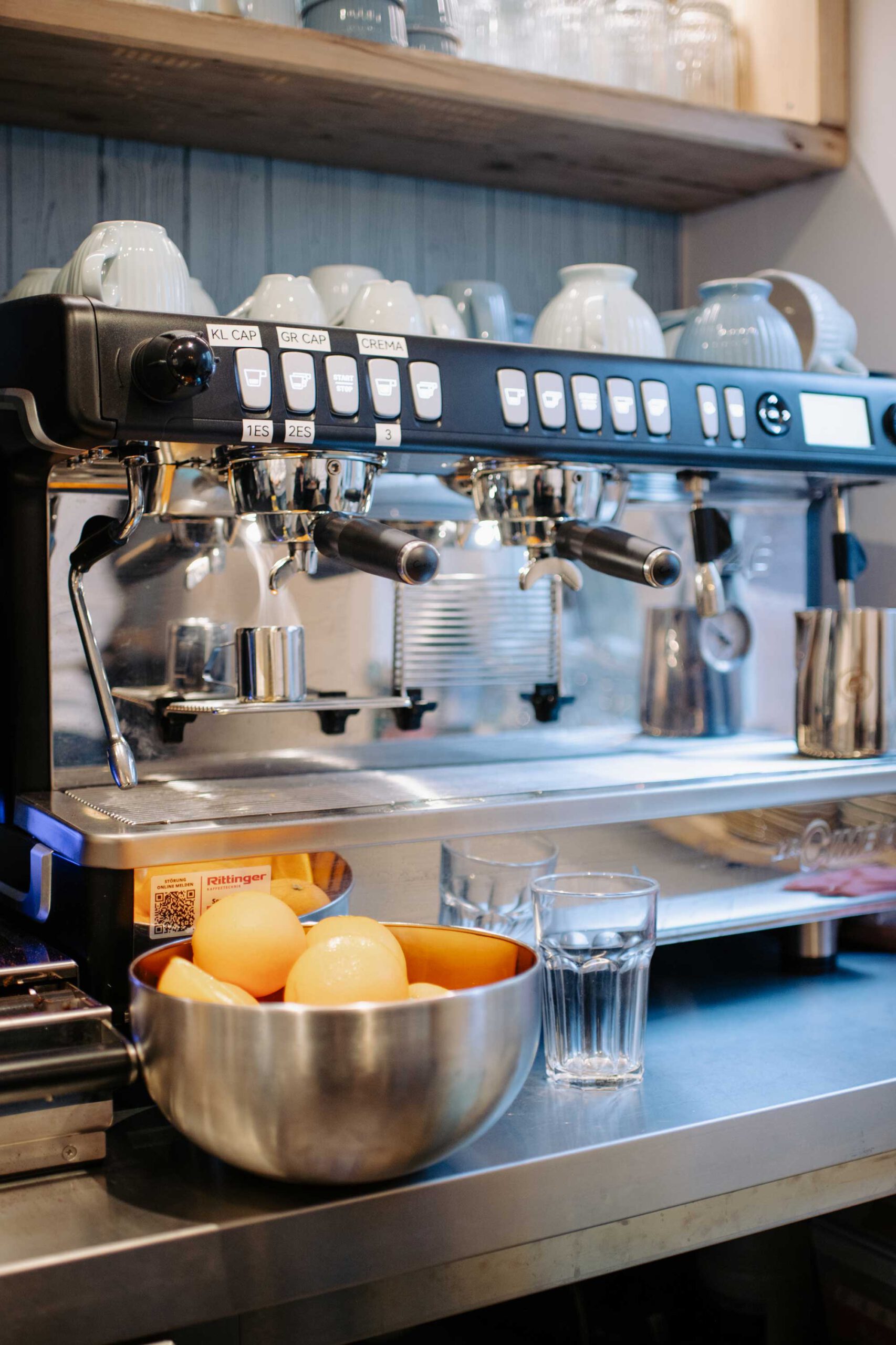 Eine Espresso Maschine und eine Schale mit Orangen